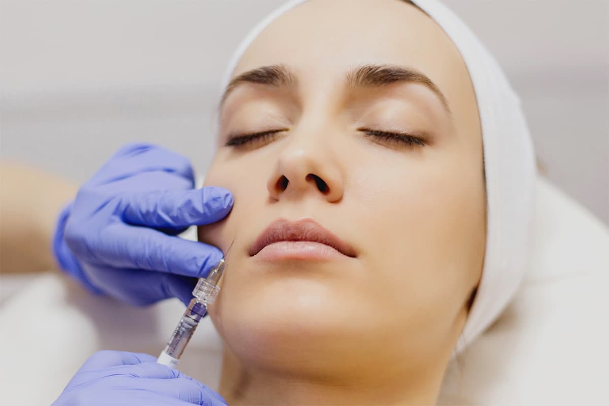 Femme en plein traitement du visage par injection d'acide hyaluronique